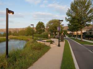 Sendero ribereño peatonal y ciclista con iluminación nocturna temprana – Proyecto urbanístico residencial Cipolletti, Río Negro. Paisajismo integrado y mobiliario urbano